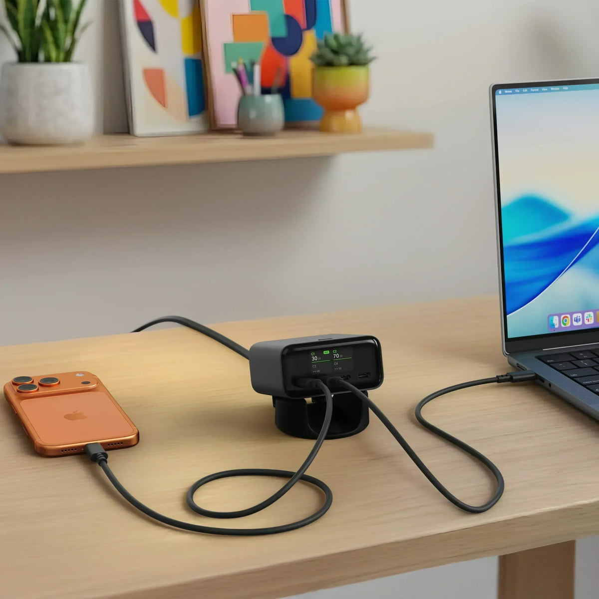 ChargeView™ 140W desktop charger featuring a digital power display, simultaneously charging a laptop and smartphone on a clean home office desk.