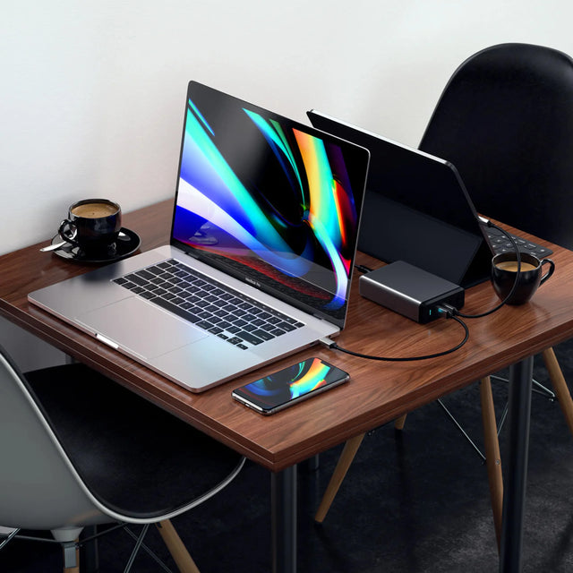 Satechi 108W Pro USB-C PD Desktop Charger charging a MacBook and iPad on a coffee table. 