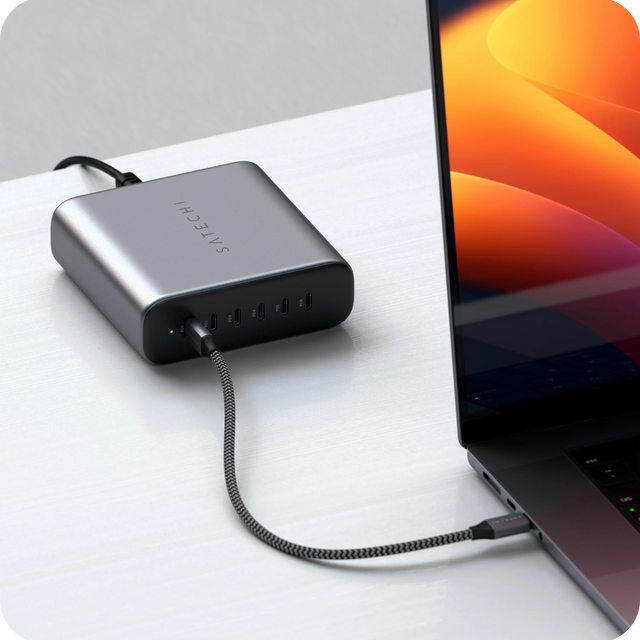 Satechi  200W USB-C 6-Port PD GaN Charger connected to a MacBook via USB‑C on a desk, shown during active charging.