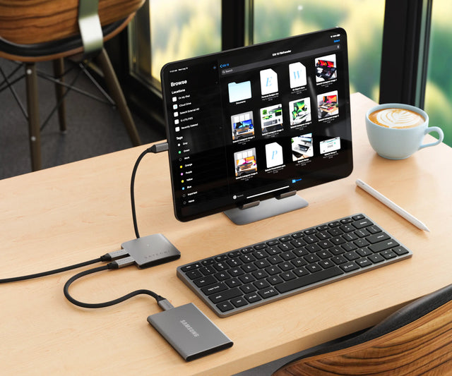 Satechi 4‑Port USB‑C Hub with Power Delivery connected to an iPad on a desk setup with a keyboard and SSD, enabling external storage access and multi‑device connectivity.