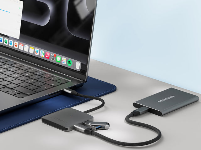 Satechi 4‑Port USB‑C Hub with Power Delivery connected to a MacBook, with multiple USB‑C accessories attached, showcasing fast data transfer and device charging capabilities.