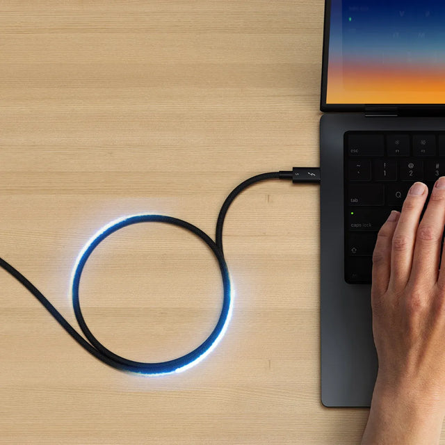 Thunderbolt 5 Pro Cable connecting a MacBook on a desk, delivering up to 240W Power Delivery for high-performance devices. 
