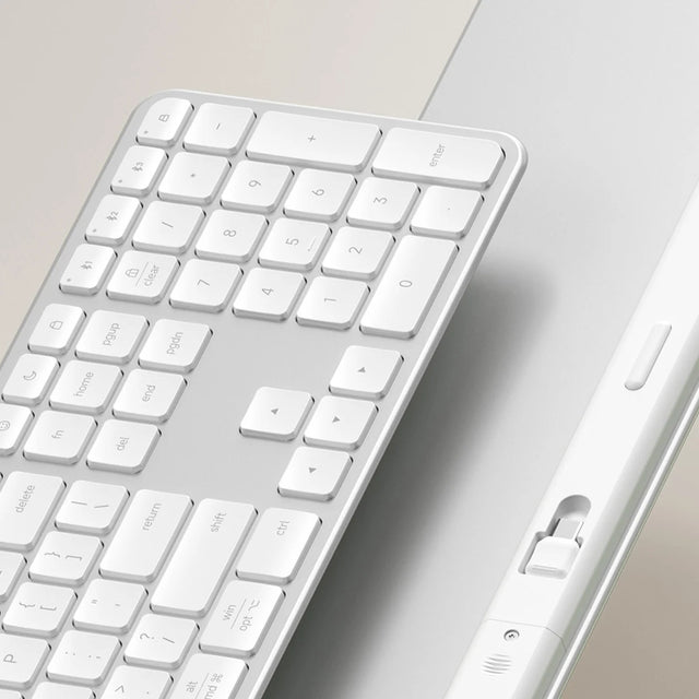 A closeup of front and back of a Slim EX3 Wireless Keyboard, showing the 2.4GHz dongle.
