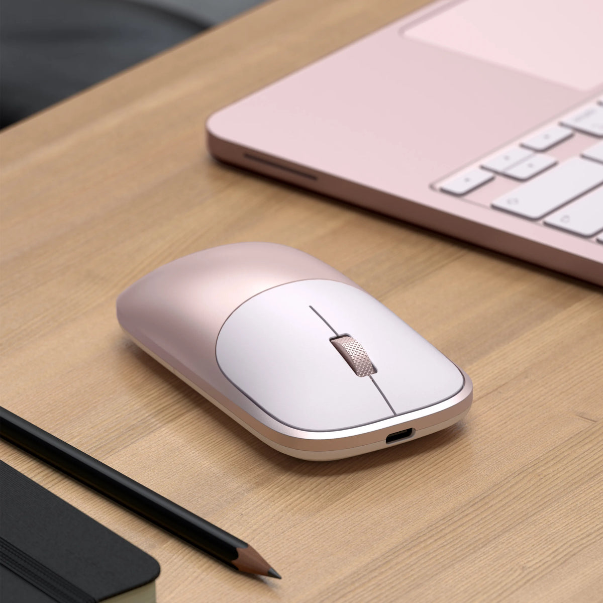 A close-up of a Satechi Slim EX Wireless Mouse in Blush on a wood desk beside a color-matched Blush MacBook Neo.
