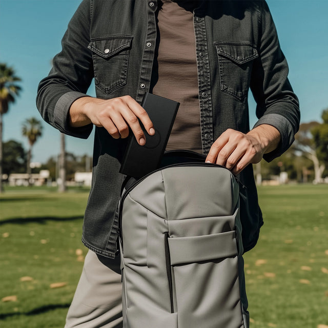 Person sliding a Vegan-Leather FindAll™ Glasses Case easily into a gray backpack.