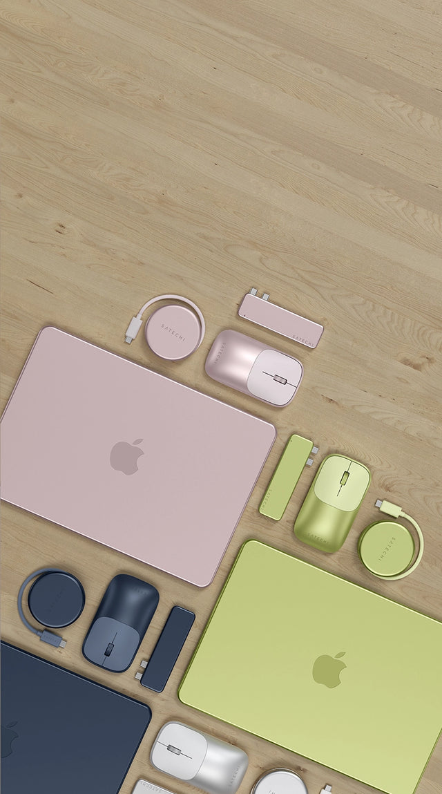 Satechi Slim EX Wireless Mouse, USB-C Snap Hub, and OntheGo™ 5-in-1 Multiport Adapter shown in four MacBook Neo colorways — Citrus, Indigo, Blush, and Silver — on a light wood desk. A blush MacBook, a citrus MacBook, and an indigo MacBook are arranged with color-matched accessories.
