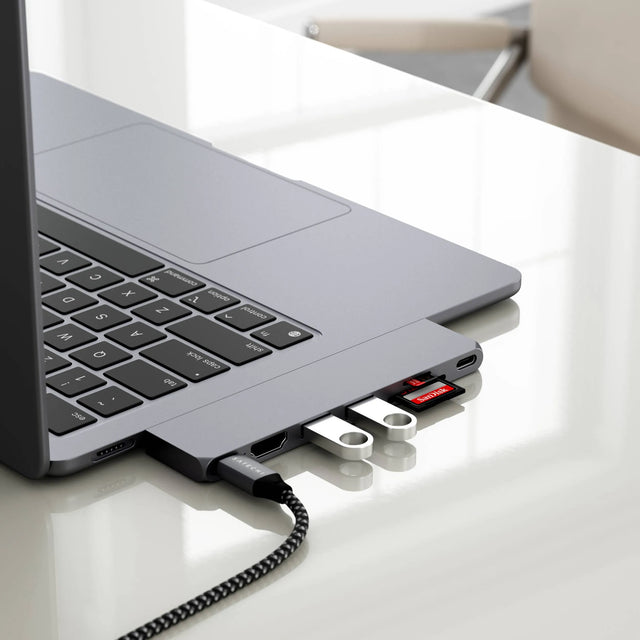 Side view of a MacBook Air M2 in the Satechi Eco Hardshell Case, connected to multiple USB‑C accessories including flash drives and an SD card seamlessly blending into MacBook.