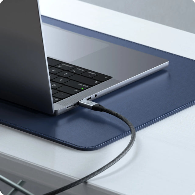 Satechi USB4 V2 Pro Cable plugged into a laptop on a desk, showing the braided design for fast data transfer, 8K video output, and high‑speed charging.