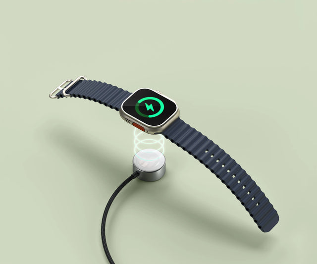 Satechi USB‑C Fast Charging Cable for Apple Watch magnetically charging an Apple Watch, with a glowing charge indicator above the circular charging pad.
