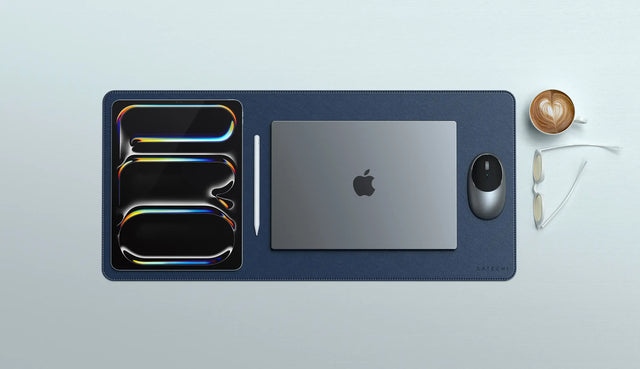 Vegan‑Leather Premium Desk Mat in navy underneath an iPad, stylus, and closed MacBook, showcasing an organized workspace layout.