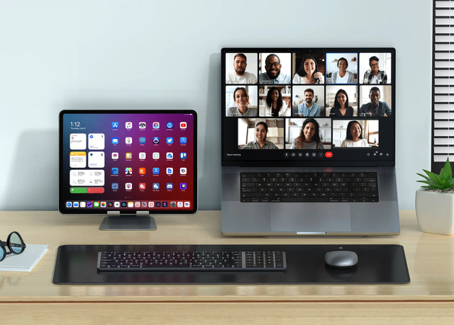 Vegan‑Leather Premium Desk Mat in black beneath a keyboard, M1 mouse, MacBook, and iPad, creating a clean and organized workstation layout.
