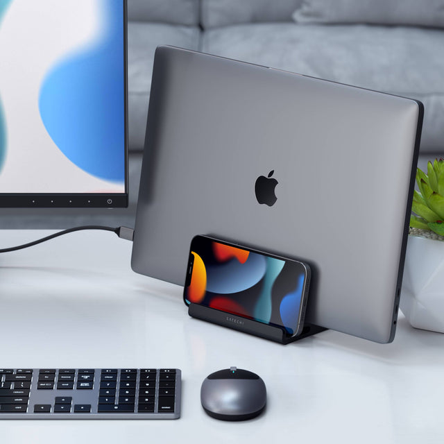 Satechi Dual Vertical Laptop Stand holding a closed MacBook and iPhone upright on a desk, creating a space‑saving and organized workstation setup.