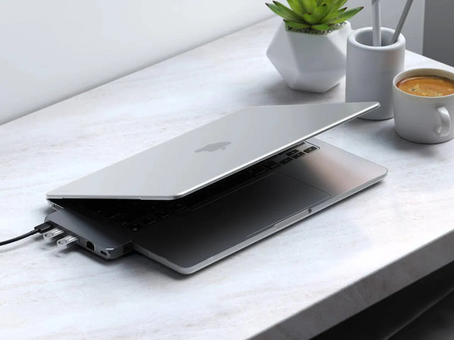 MacBook Air M2 with the Satechi Eco Hardshell Case sitting partially open on a desk beside a plant and a mug.