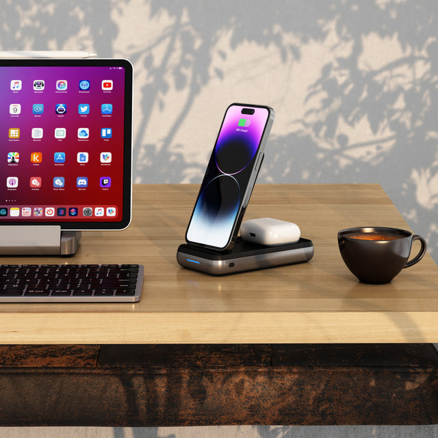 Satechi Duo Wireless Charger Power Stand in upright mode charging an iPhone and AirPods next to an iPad on stand.