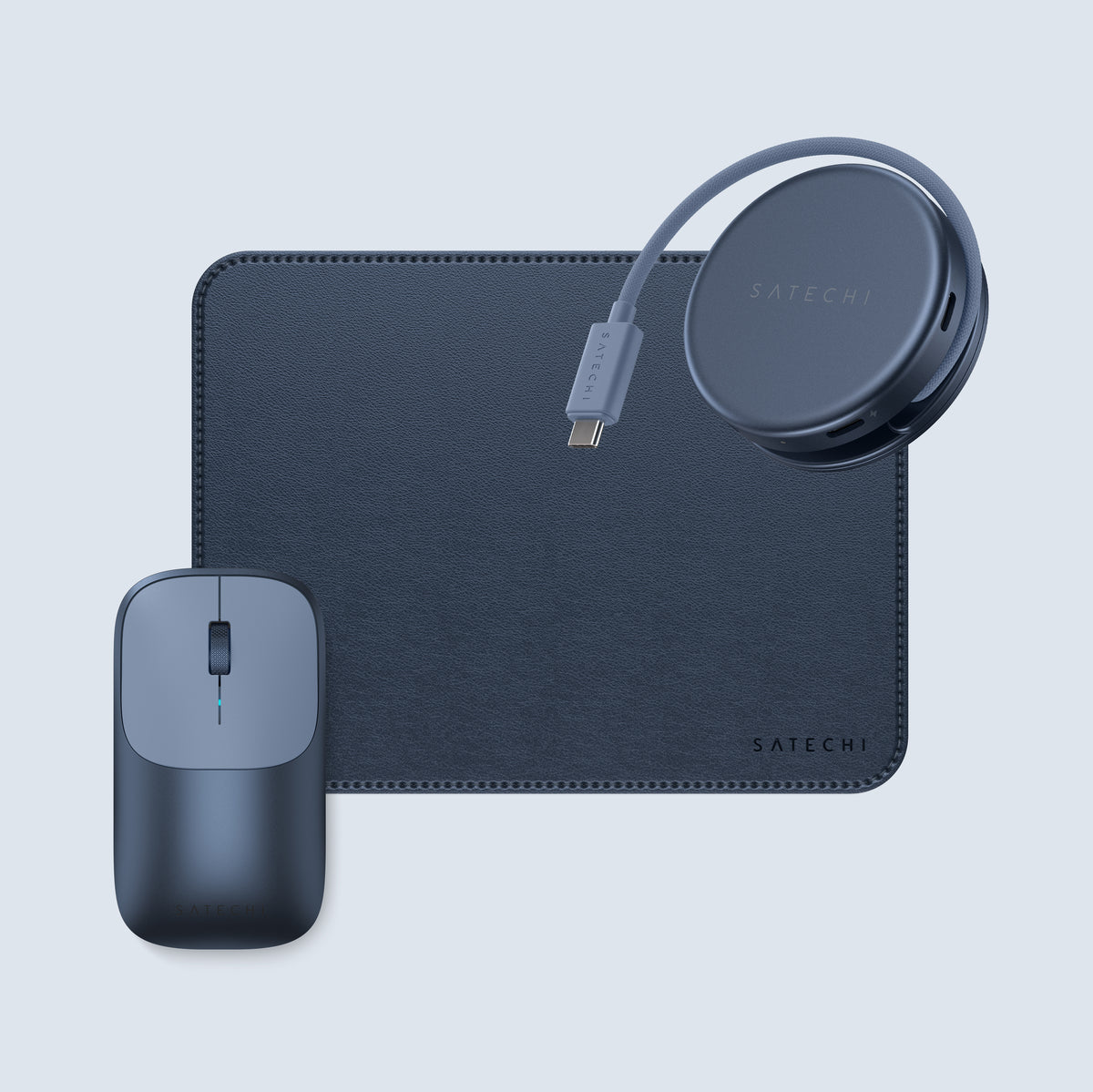 The Neo Starter back-to-school bundle:  a blue vegan-leather mouse pad, an Indigo OntheGo 5-in-1 USB-C multiport adapter with its cable coiled, and an Indigo Slim EX wireless mouse for Mac, arranged on a light blue-gray background, all branded Satechi.
