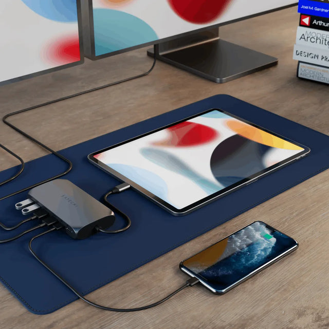 Satechi USB‑C Multimedia Adapter M1 connected to an iPhone and iPad on a desk setup, providing USB‑C charging and multi‑device connectivity.