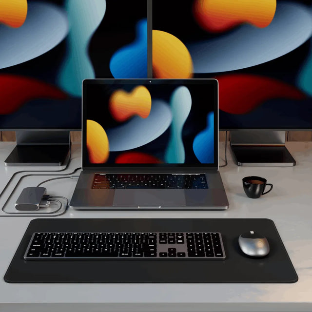 Satechi USB‑C Multimedia Adapter M1 powering a multi‑monitor workstation with a MacBook centered between two external displays using HDMI and USB‑C connections.