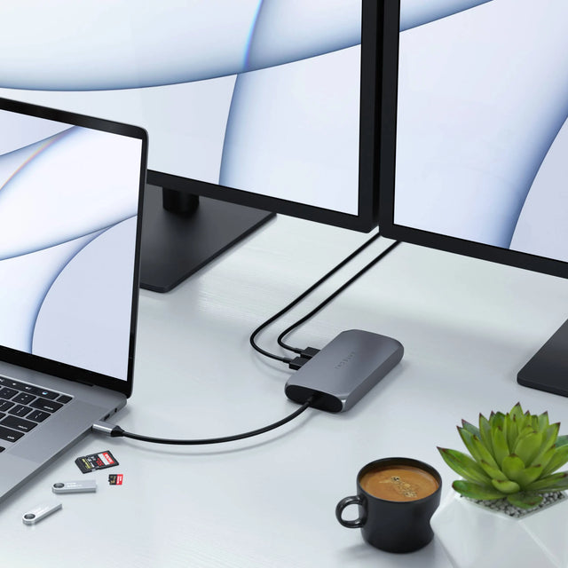 Satechi USB‑C Multimedia Adapter M1 connected to a MacBook and dual monitors, showing multiple active ports for HDMI, USB‑C, and USB‑A connectivity.