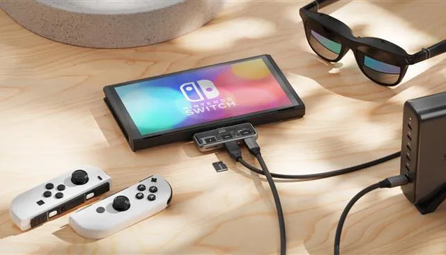 Satechi Mobile XR Hub with microSD Reader connected to a Nintendo Switch, showing dual cables and a microSD card beside the hub, highlighting portable gaming connectivity.