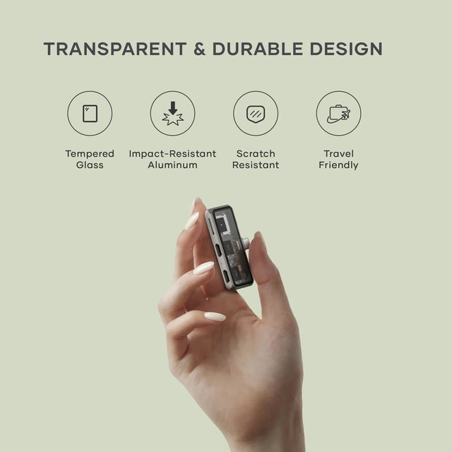 Hand holding the Satechi Mobile XR Hub with microSD Reader beside icons showing its features: tempered glass, impact‑resistant aluminum, scratch‑resistant build, and travel‑friendly design.