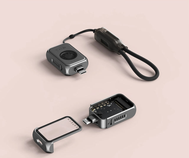 Satechi Mini NVMe SSD Enclosure shown opened with its internal components exposed, including the removable tempered‑glass cover, aluminum body, and USB‑C connector, displaying the compact modular design.