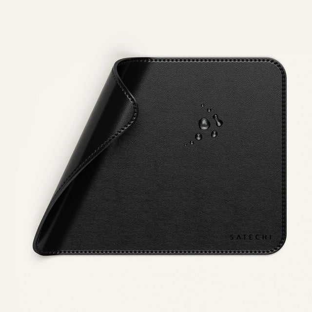 Close‑up of the Vegan‑Leather Premium Mouse Pad with water droplets on its surface, highlighting its smooth, durable, and easy‑clean vegan‑leather material.