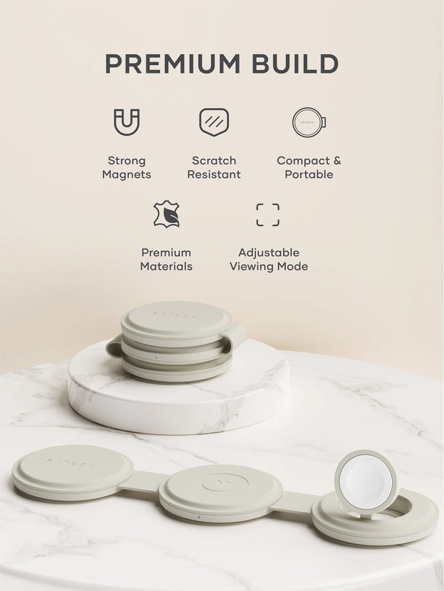 Two OntheGo™ 3-in-1 Chargers on a marble platform, one folded and one laid out flat, with the words Premium Build, strong magnets, scratch resistant, compact and portable, premium materials, and adjustable viewing mode, placed nearby. 