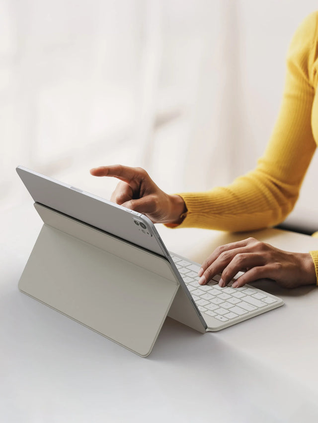 Person using a with OntheGo™ Bluetooth Keyboard with Stand on a white surface.