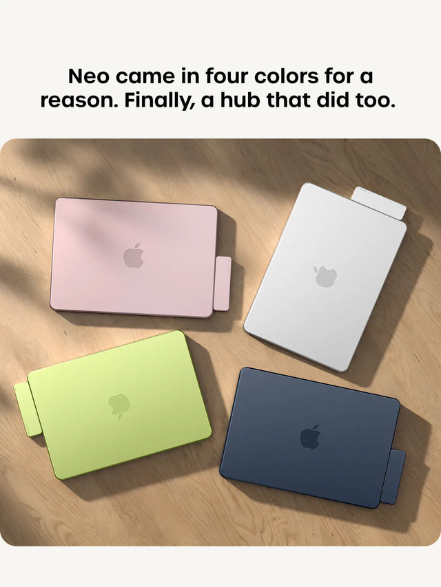 headline "Neo came in four colors for a reason. Finally, a hub that did too," . Right: four MacBooks in matching Blush, Silver, Citrus, and Indigo shown top-down on a wood table, each with a color-matched USB-C Snap Hub attached.