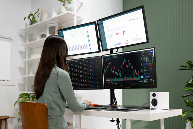 Person working at a desk with multiple computer monitors connected by the Thunderbolt 4 Docking Station with DisplayLink, up to 6K/60Hz on Mac. 