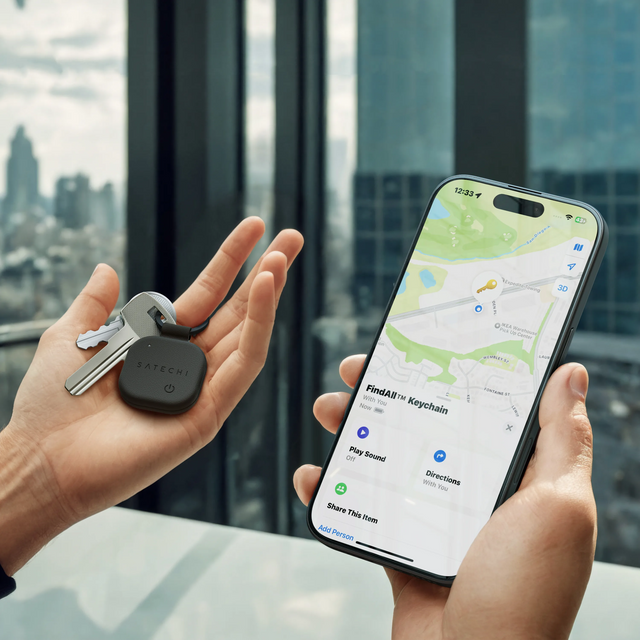 Person holding keys with the Satechi Vegan‑Leather FindAll Keychain next to an iPhone displaying the item’s location in the Find My app.