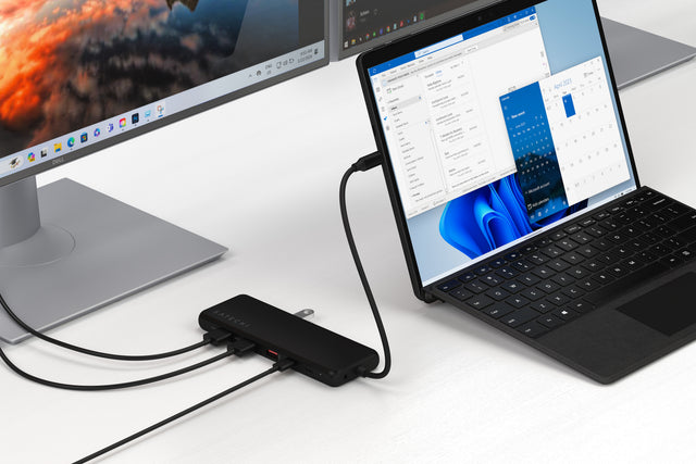 13‑in‑1 USB‑C Triple Display Multiport Adapter connected to a laptop, with multiple HDMI and USB cables attached, demonstrating multi‑monitor output and expanded connectivity for a full desktop setup.