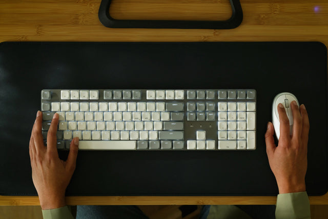 Two hands typing on a SM3 Slim Mechanical Backlit Bluetooth Keyboard, showing full sized layout and backlight. 
