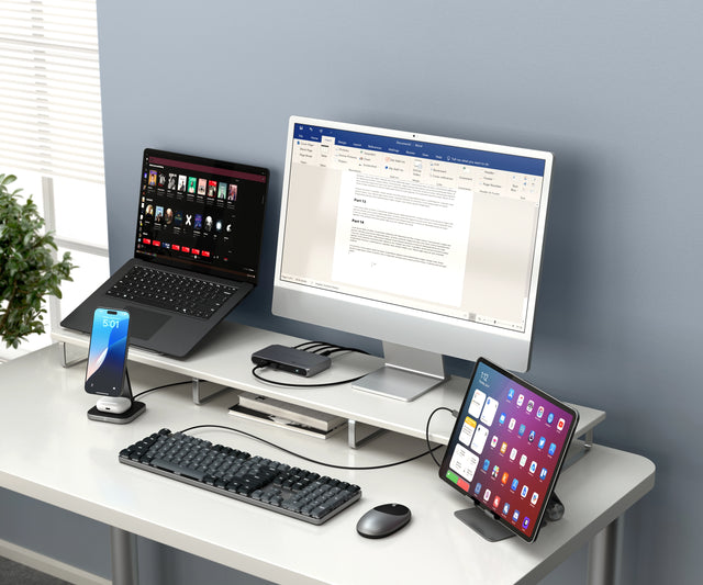 A SM3 Slim Mechanical Backlit Bluetooth Keyboard used in a modern desk setup, showcasing its abilty to type on multiple devices like an iPad, iPhone, MacBook, and iMac. 