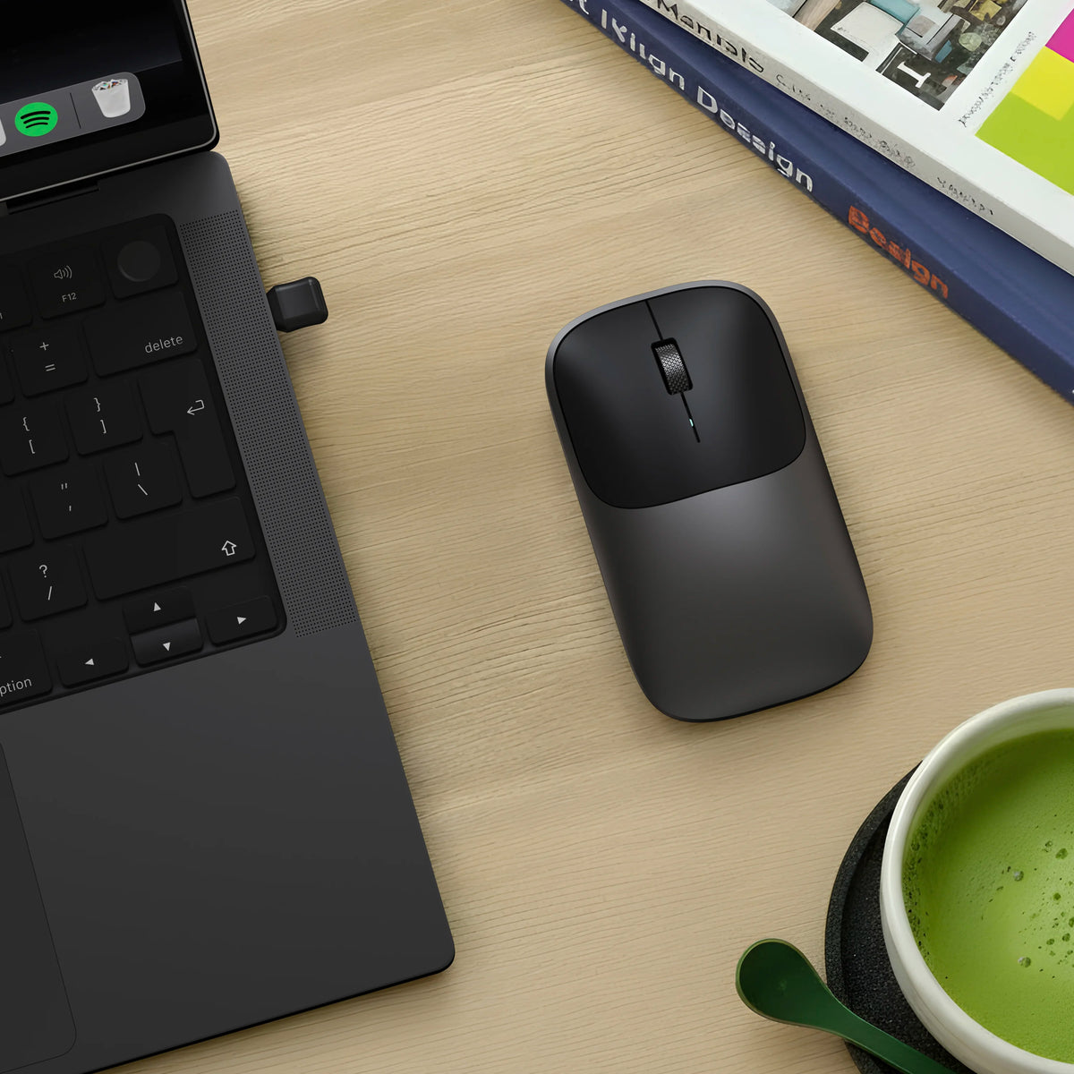 Satechi space black Slim EX Wireless Mouse on desk next to space black MacBook Pro.