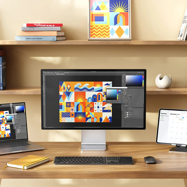 A modern desk setup showing a large monitor, the Slim EX3 Wireless Keyboard, the Slim EX Wireless Mouse, wirelessly connected to an iPad, iMac, and MacBook. 