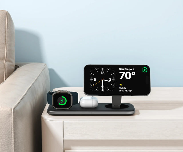 Satechi Qi2 Trio Wireless Charging Pad charging an iPhone, Apple Watch, and AirPods on top of coffee table.