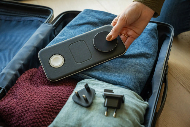 Satechi Qi2 Trio Wireless Charging Pad charging folded away, being placed into a suitcase full of clothes.