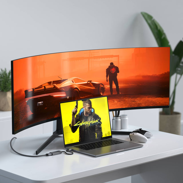MacBook connected to an ultrawide monitor using a Satechi USB‑C to HDMI 2.1 8K Adapter, displaying a high‑resolution gaming scene.
